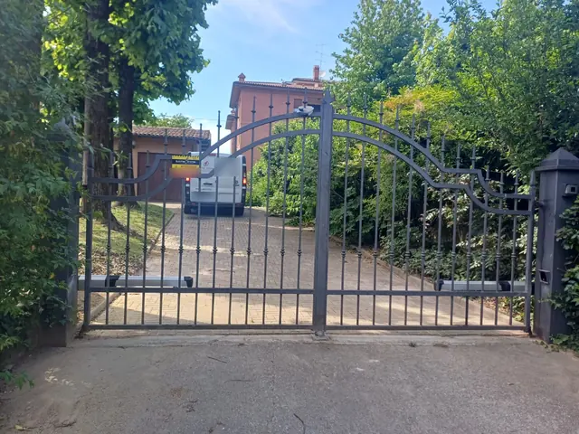 Cancello a due ante automatizzato con attuatori lineari su un viale privato